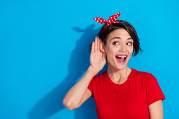 Photo of nice millennial brunette lady listen secret wear red t-shirt headband isolated on blue...