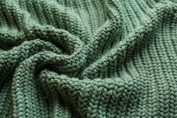 Beautiful pale green knitted fabric as background, closeup