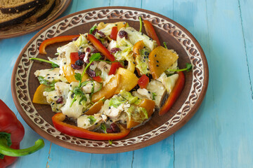Salad with chicken and cheese, with herbs, persimmons, bell peppers. The concept of diet food. Delicious salad in a bowl on a wooden background, selective focus.
