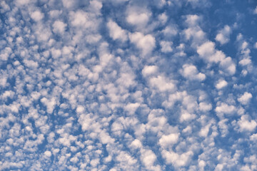 Bright landscape of white puffy clouds spread on blue clear sky