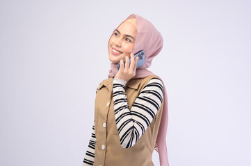 Portrait of beautiful woman with hijab using cellphone on white background