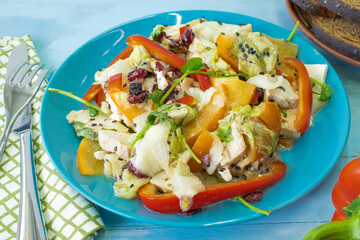 Salad with chicken and cheese, with herbs, persimmons, bell peppers. The concept of diet food. Delicious salad in a bowl on a wooden background, selective focus.
