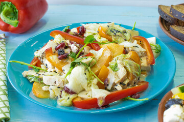 Salad with chicken and cheese, with herbs, persimmons, bell peppers. The concept of diet food. Delicious salad in a bowl on a wooden background, selective focus.
