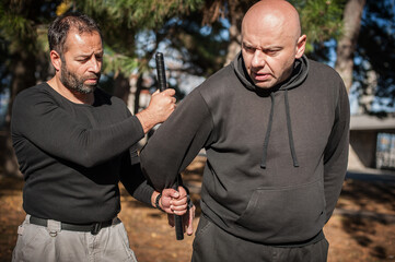 Instructor demonstrates fighting, apprehension and arrest techniques using rubber baton