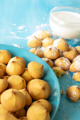Shortbread cookies consisting of butter, flour, and jam filling, view of baked sweet cookies and a glass of milk on a wooden background, selective focus
