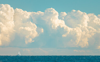 Naklejka na ściany i meble sailboat on the horizon under big clouds