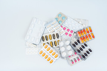 Tablets and medical capsules in a blister pack isolated on white background - obrazy, fototapety, plakaty