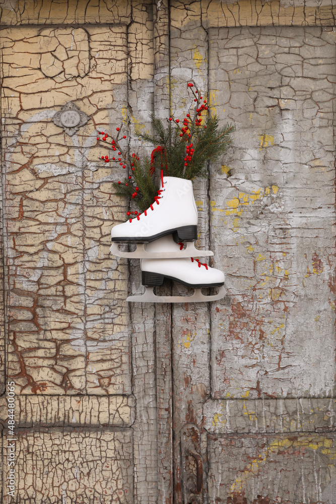 Canvas Prints Pair of ice skates with Christmas decor hanging on old wooden door