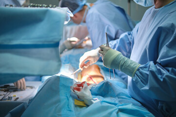 Team of surgery doctors operating a patient in surgical room. Healthcare and medical aid concept