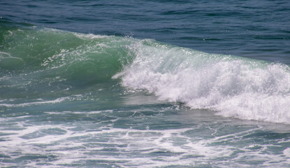 Fototapeta na wymiar Seascape with a wave rolling towards the beach