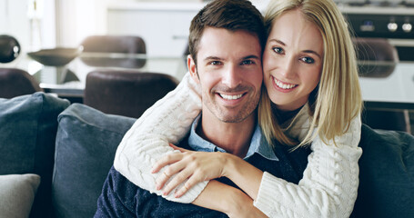 Were young and in love. Cropped portrait of an affectionate young couple sitting on their sofa at home.