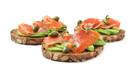 Delicious sandwiches with salmon, avocado and capers on white background