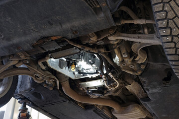 Modern car in a car service on a lift. Automatic transmission repair. - obrazy, fototapety, plakaty