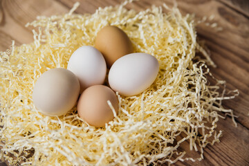 Easter eggs of natural color in a nest on a wooden background. Preparation for the Easter holiday.
