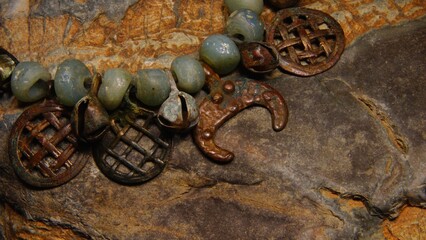 Ancient pagan necklace with bells and moon amulet on stone background selective focus	