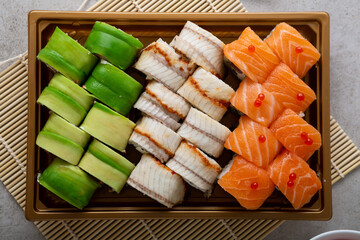 Overhead view of sushi rolls in take away tray