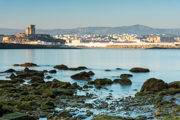 Long exposure view of the coastal town of Tarifa from the rocky beach of the Island of Tarifa at...