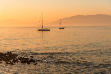 View of sailing boats on the beach at sunset with mountains in the background, Tarifa, Cadiz, Andalusia, Spain
