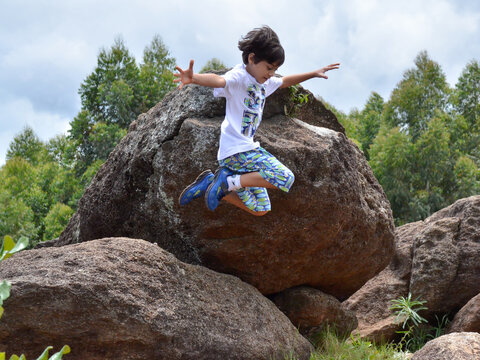 Boy Jumping Off A Rock