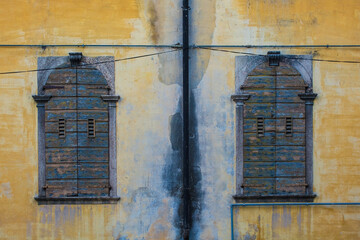 Two wooden shuttered windows in a medieval building in the historic centre of Belluno, in Veneto,...