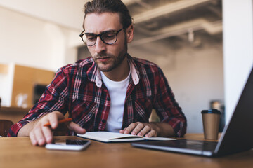 Fototapeta premium Millennial businessman working at desk in office