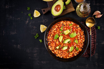 Chili con carne in bowl on dark background. Mexican cuisine. Top view, above