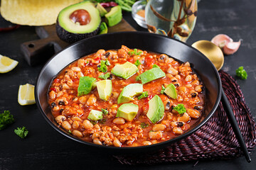 Chili con carne in bowl on dark background. Mexican cuisine.