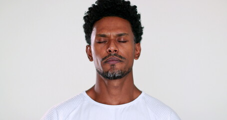 African man closing eyes trying to relax and contemplate life in meditation mindful
