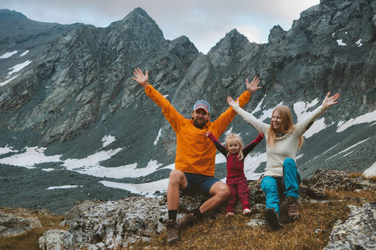 Family vacations travel hiking in mountains camping outdoor adventure active healthy lifestyle  parents with child father and mother raised hands