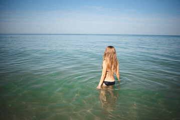 girl in a bathing suit goes into the sea