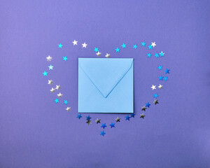 kraft blue envelope  surrounded by confetti stars in the shape of a heart  on a paper lilac  color background. Mother's Day, Easter, Valentine's Day, holiday concept. Flat lay.