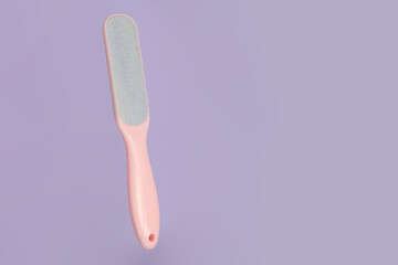 Pink foot grater on a purple background, foot care, clean heels. Space for copying text