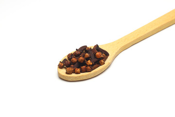 Dry cloves in wooden scoop isolated on white background with clipping path. Top view. Flat lay