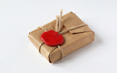 mail parcel wrapped in craft paper and sealed with a red wax seal on a white background. Packet...