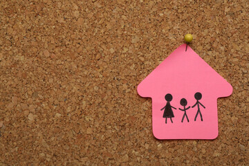 House shaped note with drawing of family pinned to cork board, space for text. Child adoption...