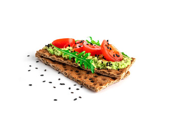 Avocado sandwich with avocado cream and rye crisp bread for snack. Fiber, fitness and diet food. Rye bread with guacamole, arugula and cherry tomatoes isolated on a white background.