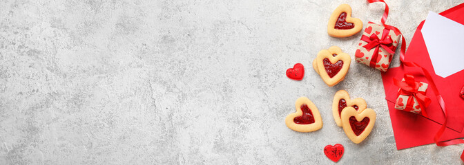 Tasty heart-shaped cookies with envelopes and gifts on grunge background with space for text. Valentine's Day celebration