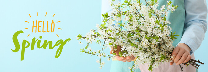 Woman with beautiful blooming tree branches on color background. Hello spring