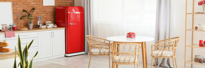 Interior of modern kitchen with stylish red refrigerator