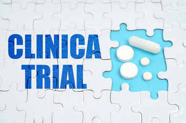 On the puzzles there is an inscription - CLINICAL TRIAL, on a blue background pills.