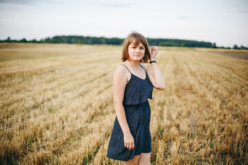 A beautiful girl and a field on which they threshed grain. Woman after harvest. Girl and yellow...