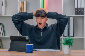 student at home with computer and surprised expression