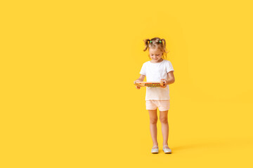 Adorable little girl with abacus on yellow background