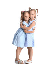 Adorable little sisters hugging on white background