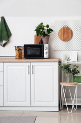 Modern microwave on counter near white wall in kitchen