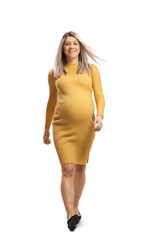 Full length portrait of a happy pregnant woman in a yellow dress walking towards camera and smiling