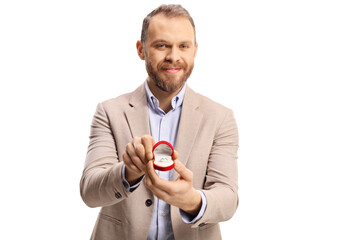 Happy bearded guy holding an engagement ring in a box