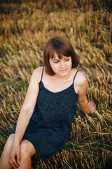 A beautiful girl and a field on which they threshed grain. Woman after harvest. Girl and yellow...