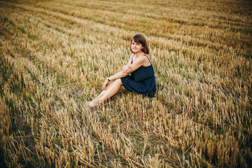 A beautiful girl and a field on which they threshed grain. Woman after harvest. Girl and yellow...