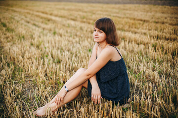 A beautiful girl and a field on which they threshed grain. Woman after harvest. Girl and yellow...